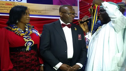 (L-r): Michael Umo (m) being installed as the president, Rotary Club of Mushin by Akin Oyegbola (r), while Umo’s wife admires…