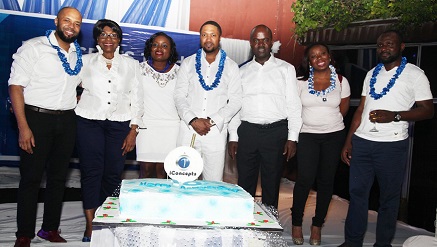 Ugo Okoye, chief executive officer of iConcepts Limited (m) flanked by some of the company’s staff while cutting the tenth anniversary cake.