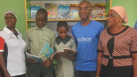 (L-r): Mrs. Elizabeth Akapo, assistant head teacher, Local Government Primary School, two pupils of the school reading the new books from the newly commissioned library, Lampe Omoyele, managing director, Nielsen West Africa and Mrs Aina Lanre, Social Mobilization Officer, Public Private Partnership, Ikeja LG, during the commissioning of the school library donated by the Nielsen Nigeria to mark 2015 Nielsen Global Impact Day (NGID) in Lagos recently.