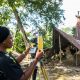 Dr. Ijeoma adjusts the total station at Busanyin shrine